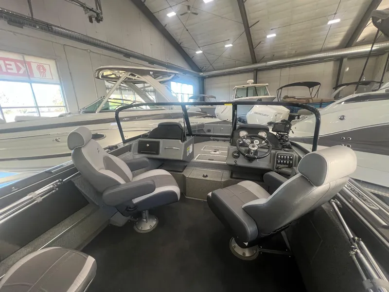 Slide: The Image of 2023 Starcraft Fishmaster 196 boat interior with seating and control panel in showroom. - 9