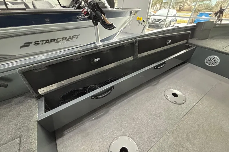Slide: The Image of 2023 Starcraft Storm 166 SC boat interior with open storage compartment and visible branding. - 13