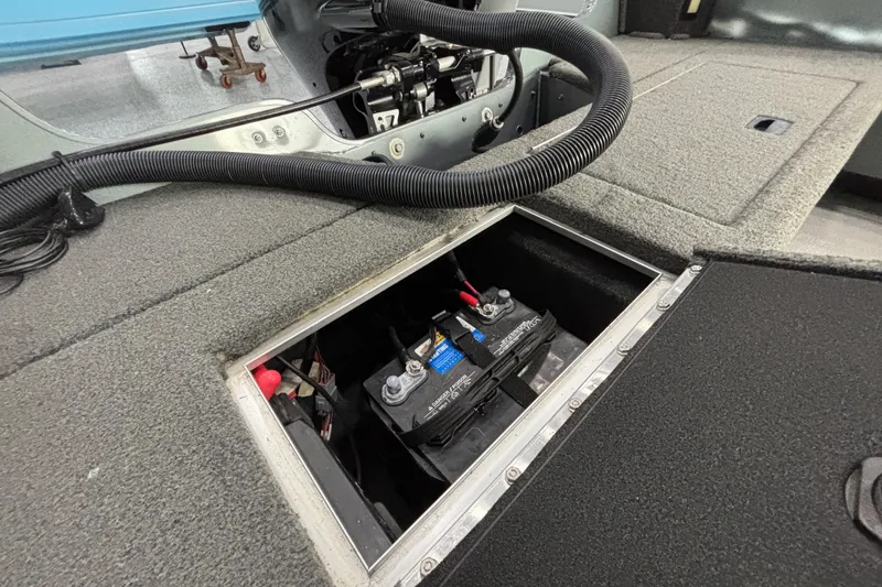 Slide: The Image of 2023 Starcraft Storm 166 SC boat battery compartment with wiring and carpeted interior. - 16