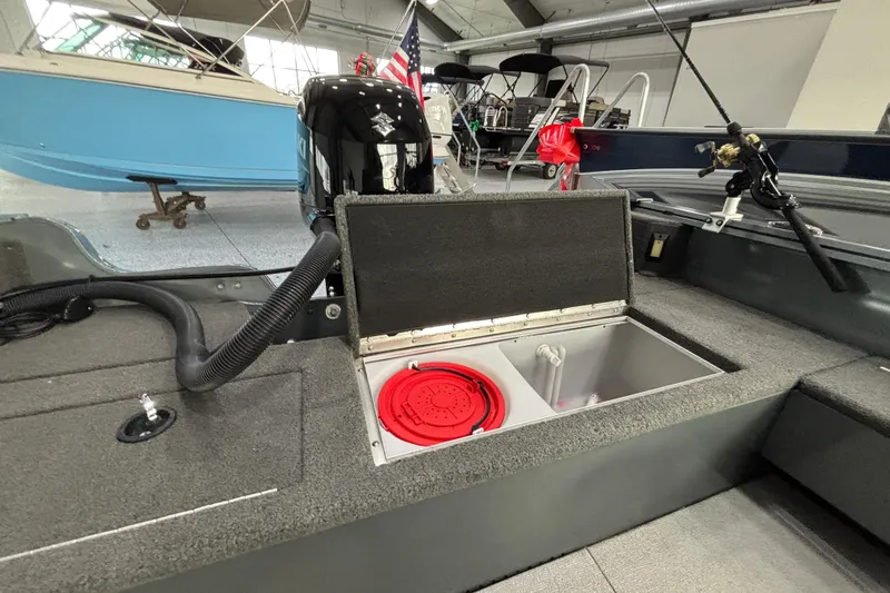 Slide: The Image of 2023 Starcraft Storm 166 SC boat interior with open storage compartment and fishing rod. - 17