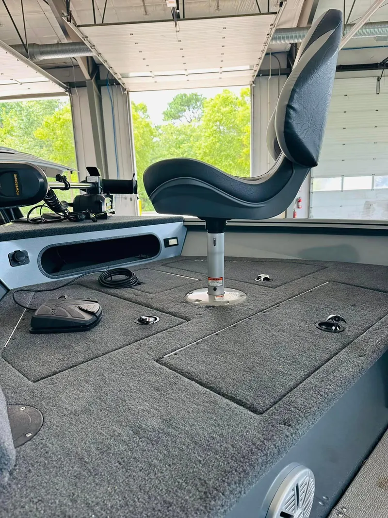 Slide: The Image of 2023 Starcraft Storm 166 SC boat interior with swivel seat and carpeted deck. - 23