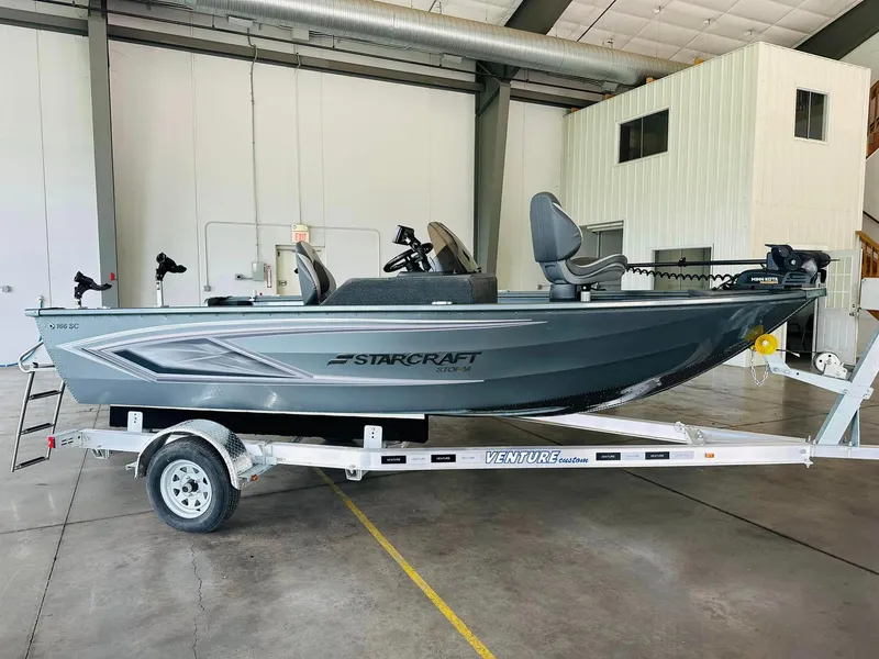 Slide: The Image of 2023 Starcraft Storm 166 SC boat on trailer in warehouse setting. - 26
