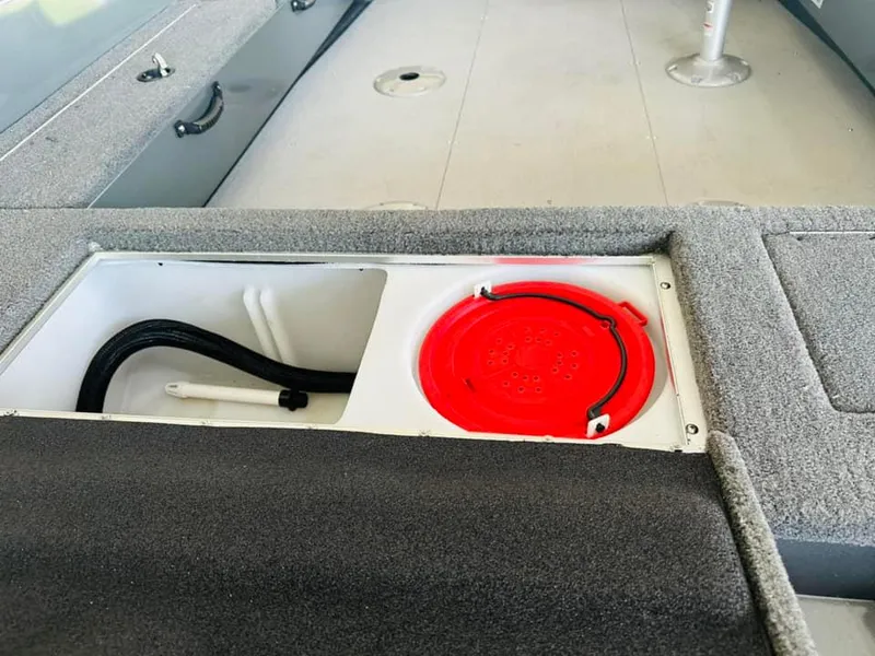 Slide: The Image of 2023 Starcraft Storm 166 SC boat interior storage compartment with red lid. - 33