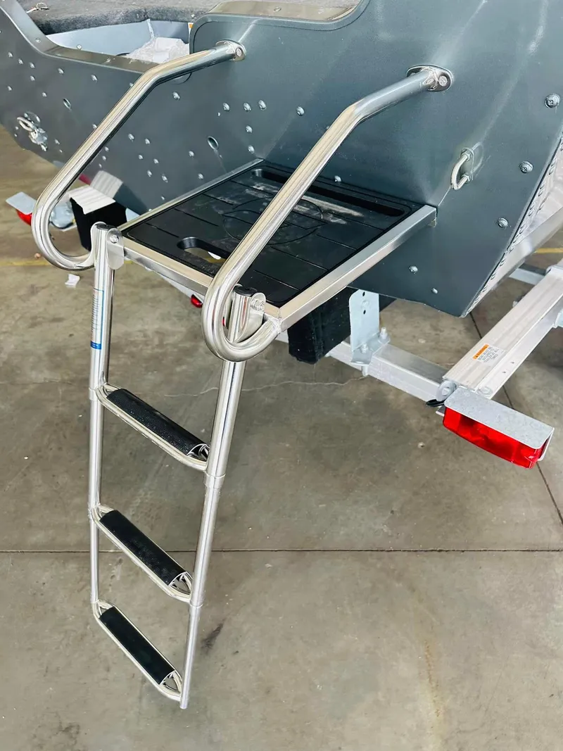Slide: The Image of 2023 Starcraft Storm 166 SC boat ladder on trailer, featuring sturdy metal steps. - 34