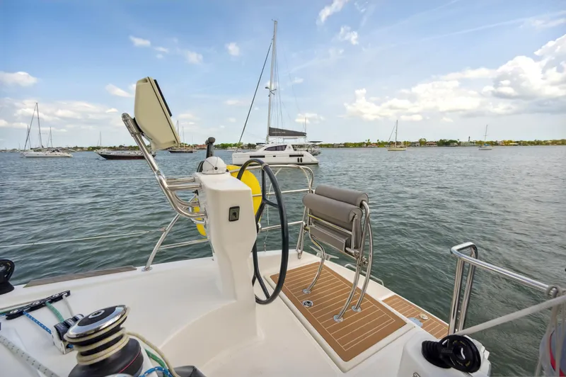 Slide: The Image of Catana 42 sailboat helm, 2016 model, overlooking serene marina waters. - 10