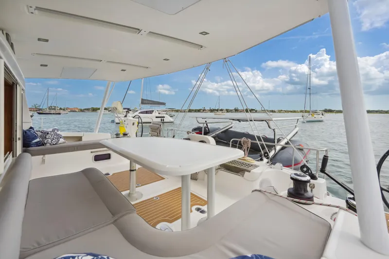 Slide: The Image of Catana 42 catamaran 2016, spacious deck with seating, docked in a sunny marina. - 20