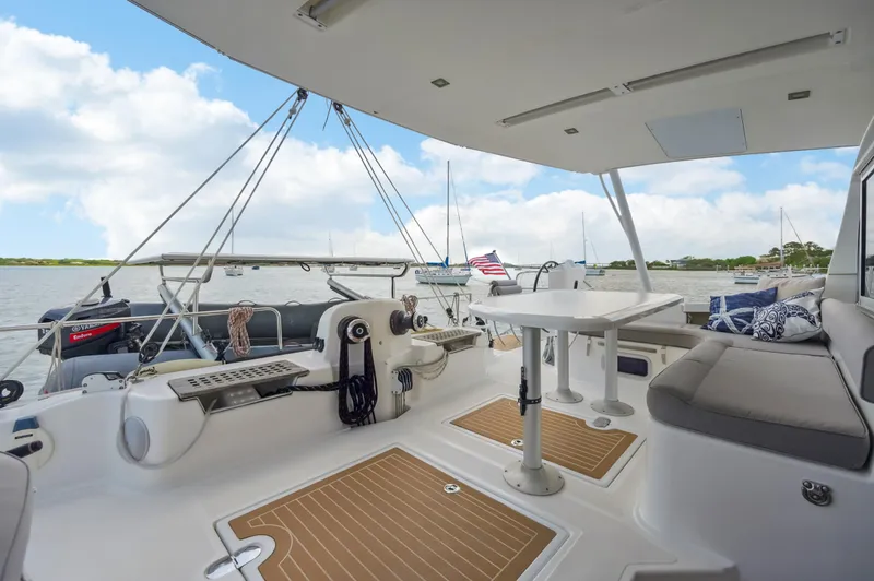 Slide: The Image of Spacious deck of 2016 Catana 42 catamaran with seating and table, overlooking serene waters. - 22