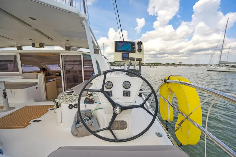 Slide: The Image of Catana 42 sailboat cockpit with steering wheel, navigation equipment, and life preserver, 2016 model. - 9