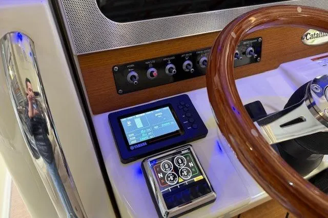 Slide: The Image of 2019 Chris-Craft Catalina 30 dashboard with wooden steering wheel and digital controls. - 17