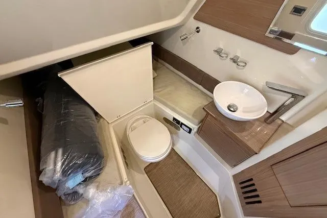 Slide: The Image of 2019 Chris-Craft Catalina 30 boat bathroom with toilet, sink, and storage area. - 22