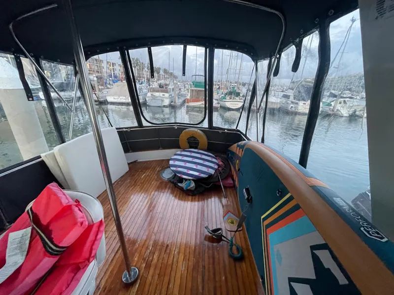 Slide: The Image of 1968 Chris-Craft Commander boat interior with wooden deck, docked at a marina. - 12