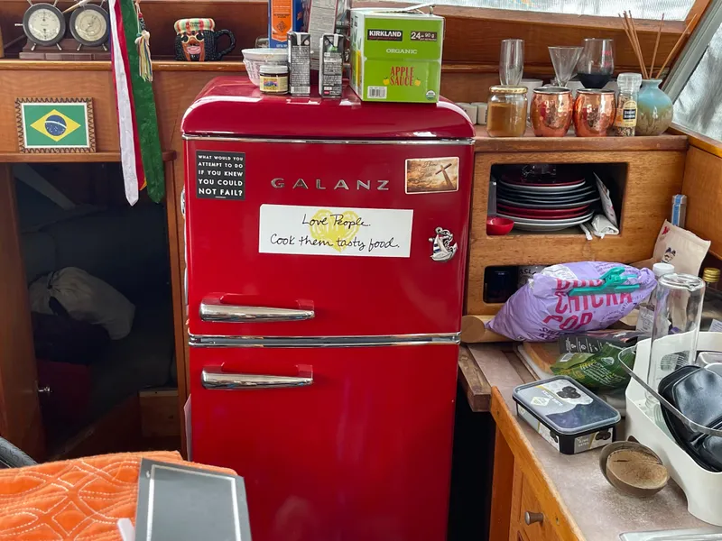Slide: The Image of Red Galanz fridge inside a 1968 Chris-Craft Commander boat, surrounded by kitchen items. - 21