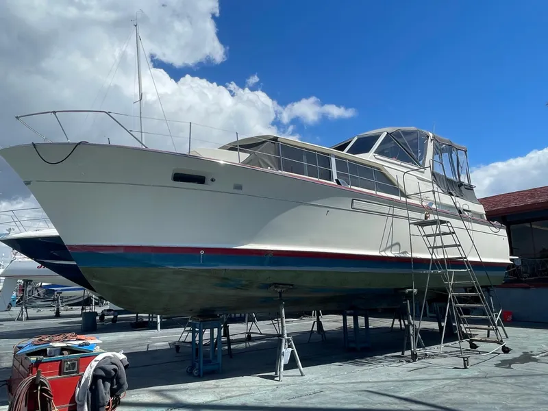 Slide: The Image of 1968 Chris-Craft Commander boat on dry dock under a clear blue sky. - 24