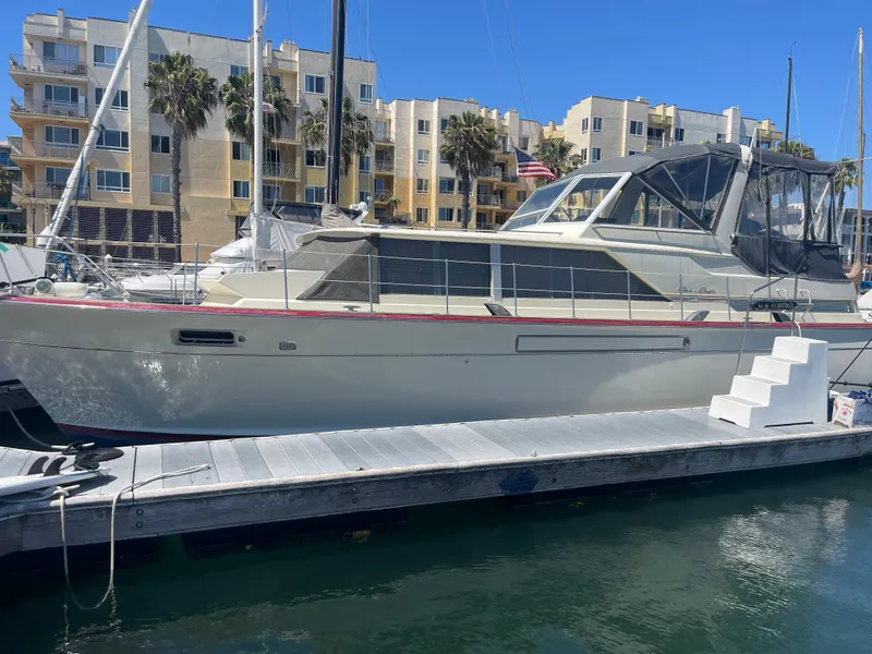 Slide: The Image of 1968 Chris-Craft Commander yacht docked at marina with modern buildings in background. - 26