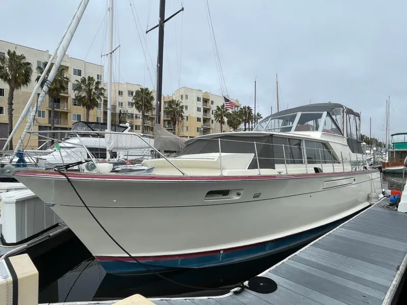 Slide: The Image of 1968 Chris-Craft Commander yacht docked at marina with modern buildings in background. - 3