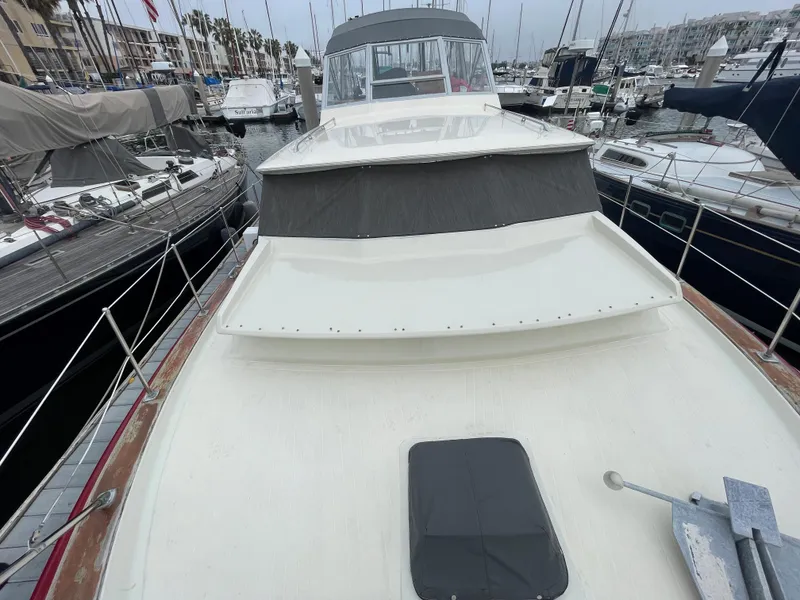 Slide: The Image of 1968 Chris-Craft Commander yacht docked in a marina, showcasing its classic design and spacious deck. - 5
