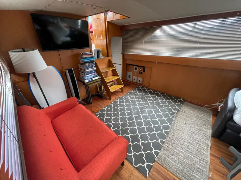 Slide: The Image of 1968 Chris-Craft Commander interior with red sofa, TV, and patterned rug. - 7