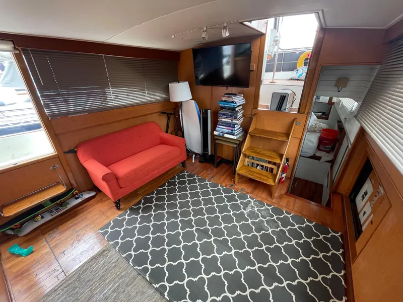 Slide: The Image of Interior of 1968 Chris-Craft Commander with red sofa, patterned rug, and wooden decor. - 9