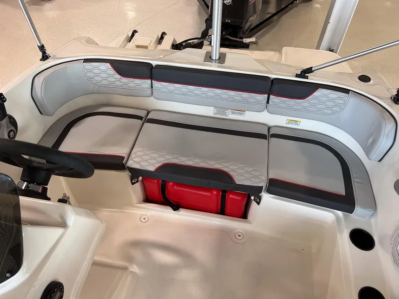 Slide: The Image of 2023 Bayliner Element M15 boat interior with cushioned seating and steering wheel. - 16