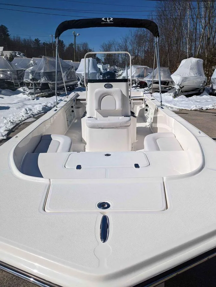 Slide: The Image of 2023 Sundance DX20 boat with seating and console, displayed outdoors in a snowy setting. - 10