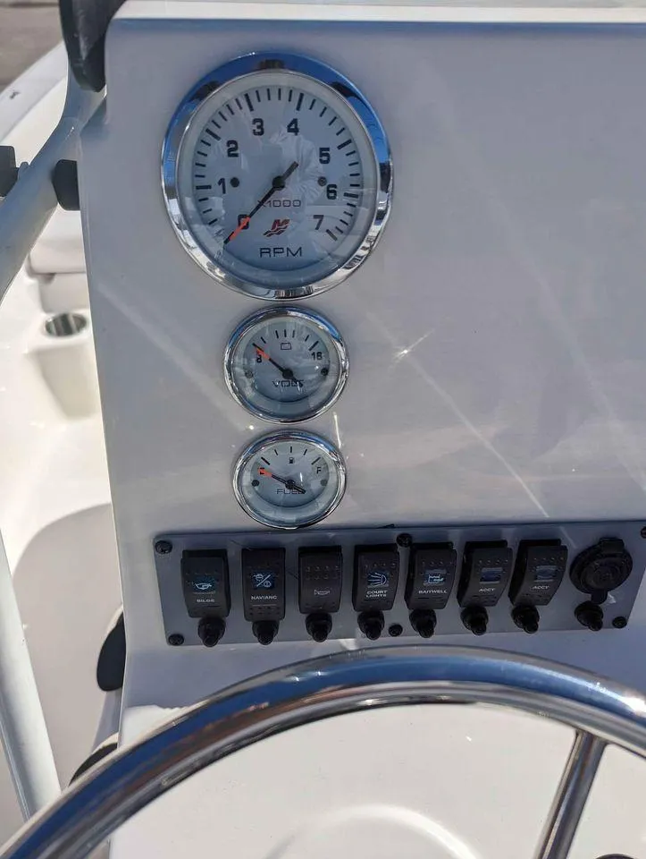 Slide: The Image of 2023 Sundance DX20 boat dashboard with RPM gauge and control switches. - 4