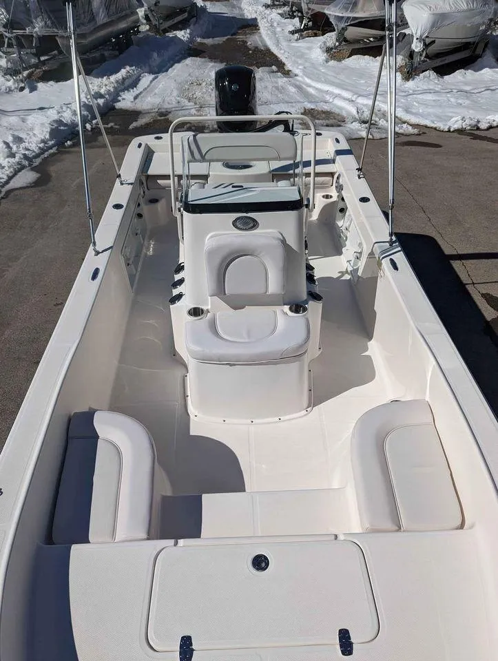 Slide: The Image of 2023 Sundance DX20 boat interior with seating and console, parked on snowy ground. - 9