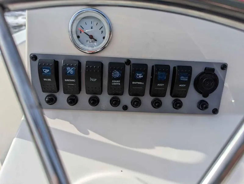 Slide: The Image of Control panel of a 2023 Sundance DX22 boat with fuel gauge and switches. - 10