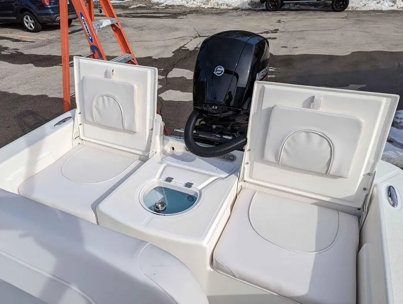 Slide: The Image of 2023 Sundance DX22 boat with outboard motor and seating area. - 13