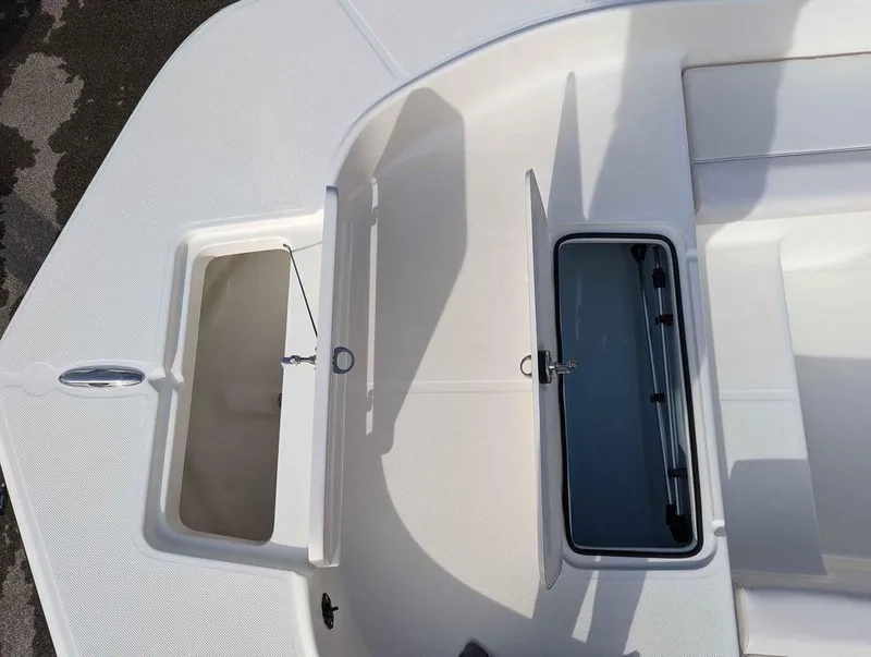 Slide: The Image of 2023 Sundance DX22 boat storage compartments and seating area. - 16