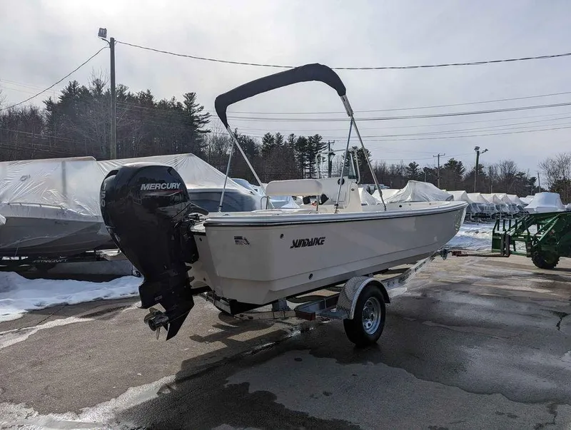 Slide: The Image of 2023 Sundance DX22 boat with Mercury outboard motor on trailer in snowy lot. - 4