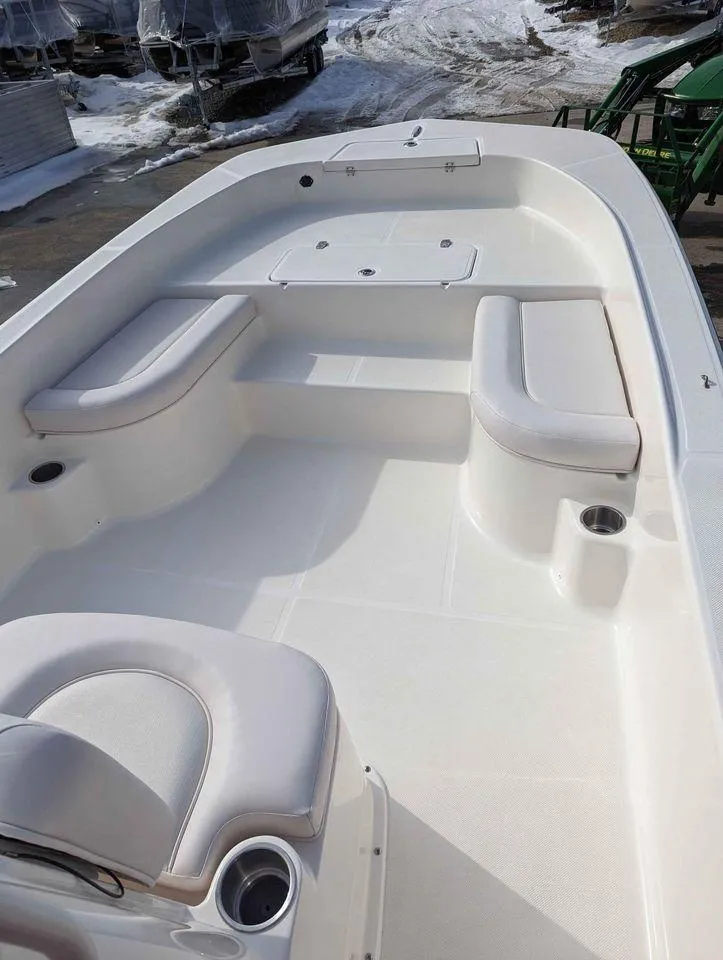 Slide: The Image of 2023 Sundance DX22 boat interior with white seating and storage compartments. - 8