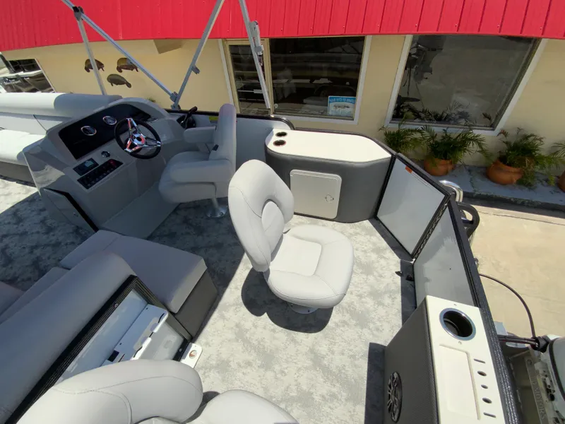 Slide: The Image of 2023 Crest Classic LX 220 SF boat interior with gray seating and helm station. - 10