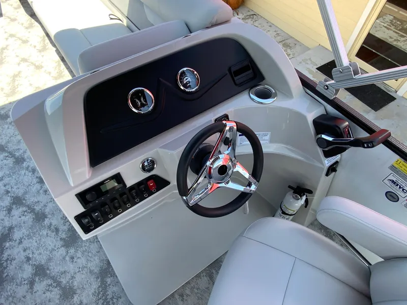 Slide: The Image of 2023 Crest Classic LX 220 SF boat dashboard with steering wheel and control panel. - 18