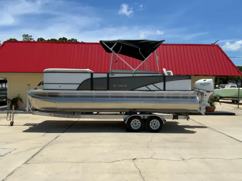The Image of 2023 Crest Classic LX 220 SF pontoon boat on a trailer. - 2