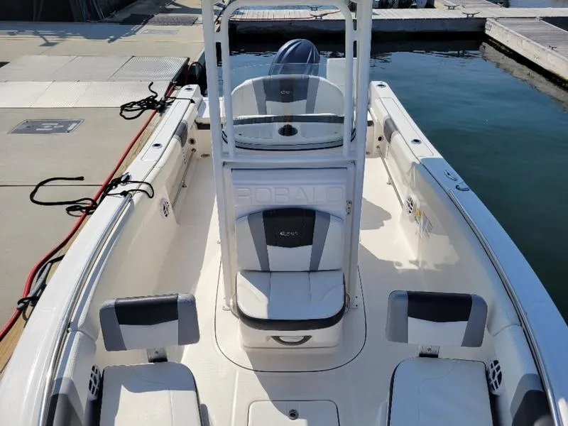Slide: The Image of 2023 Robalo R230 boat interior at dock, featuring seating and helm station. - 1