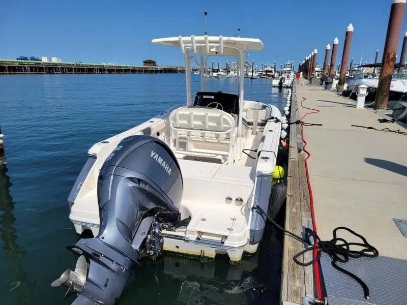 Slide: The Image of 2023 Robalo R230 boat docked with Yamaha engine, clear blue water background. - 14
