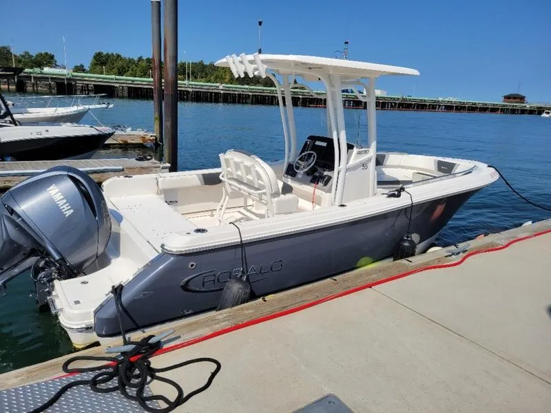 Slide: The Image of 2023 Robalo R230 boat docked with Yamaha engine, clear blue sky, and calm water. - 15