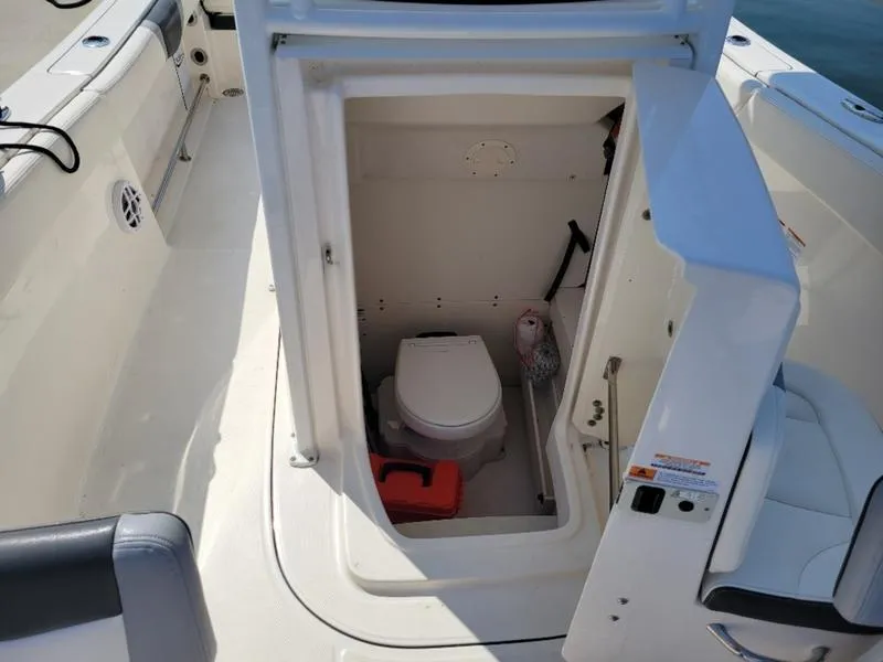 Slide: The Image of 2023 Robalo R230 boat interior with compact marine toilet. - 2