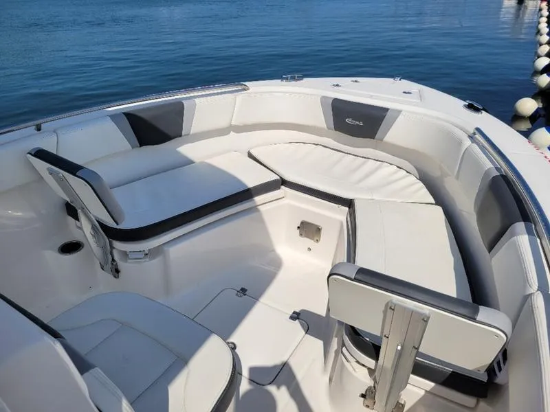 Slide: The Image of 2023 Robalo R230 boat interior with cushioned seating, on calm blue water. - 3