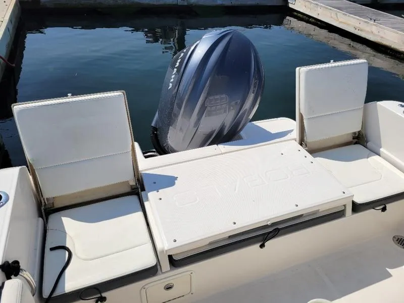 Slide: The Image of 2023 Robalo R230 boat with outboard motor and seating, docked at marina. - 4