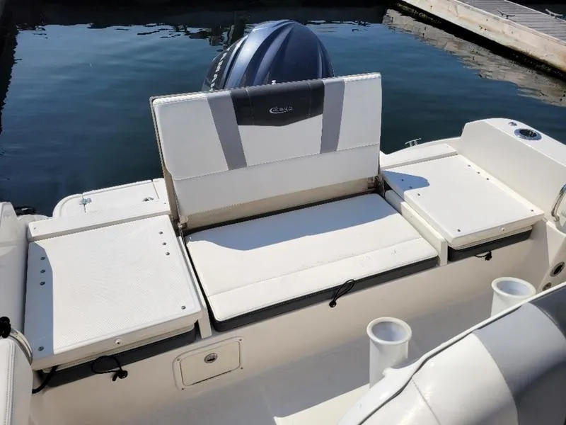 Slide: The Image of 2023 Robalo R230 boat interior with seating and motor at dock. - 6
