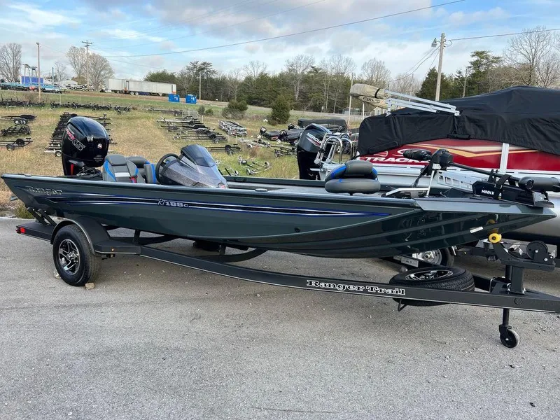 Slide: The Image of 2023 Ranger RT188C fishing boat on a trailer, parked outdoors. - 2