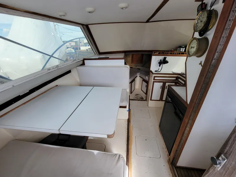 Slide: The Image of 1980 Blackfin 32 Flybridge interior with dining area and kitchenette. - 10