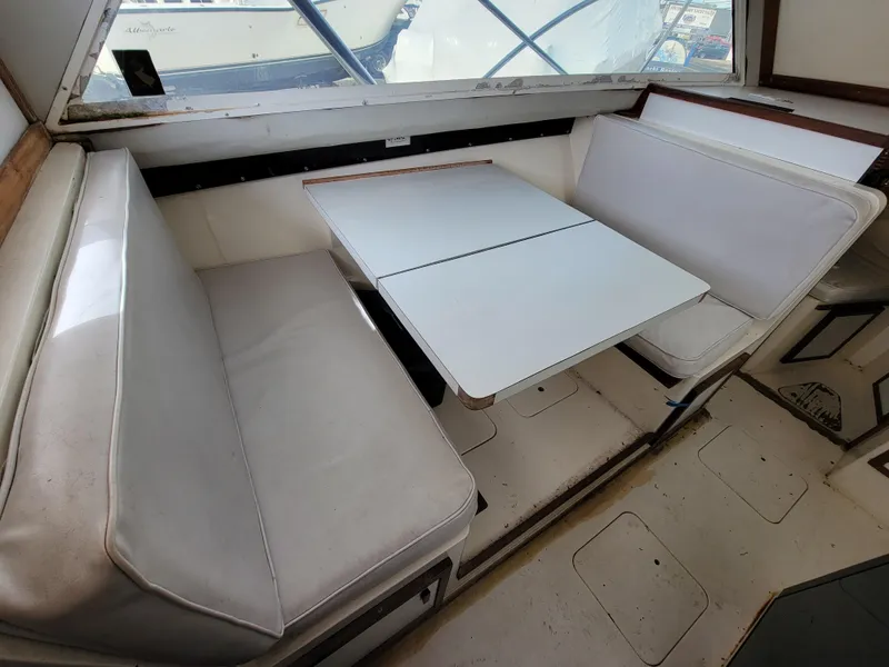 Slide: The Image of 1980 Blackfin 32 Flybridge interior seating area with white cushions and table. - 11