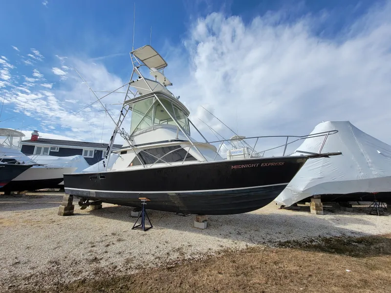 Slide: The Image of 1980 Blackfin 32 Flybridge boat on dry dock under a blue sky. - 2