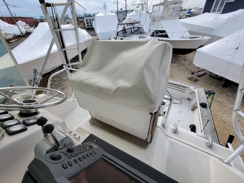 Slide: The Image of 1980 Blackfin 32 Flybridge boat helm station with covered seat and control panel. - 20
