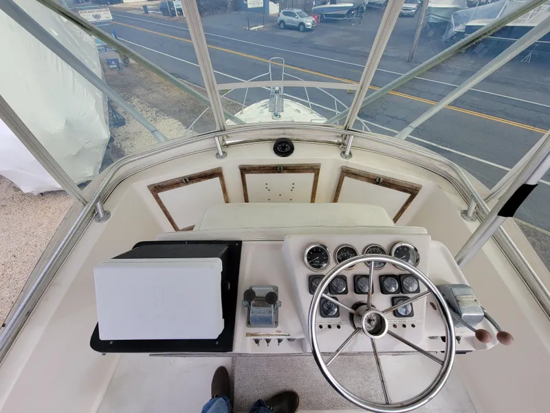 Slide: The Image of 1980 Blackfin 32 Flybridge helm station with steering wheel and instrument panel. - 22