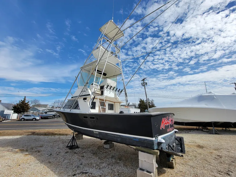 Slide: The Image of 1980 Blackfin 32 Flybridge boat on dry dock under a blue sky. - 6