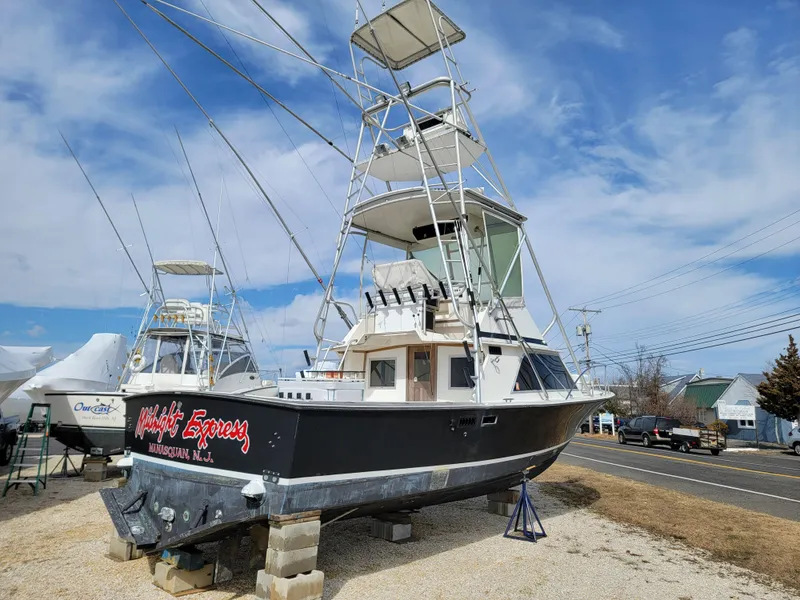 Slide: The Image of 1980 Blackfin 32 Flybridge boat on dry dock with clear sky background. - 7