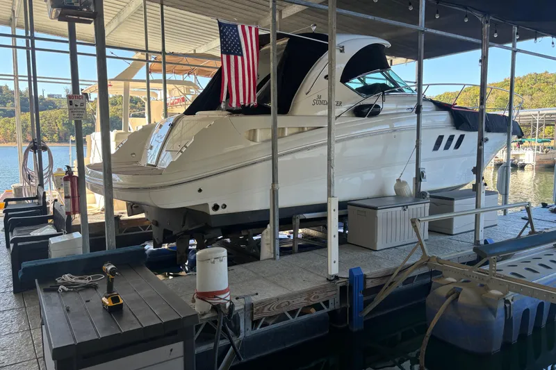 Slide: The Image of 2007 Sea Ray 38 Sundancer docked under a covered marina with an American flag. - 1